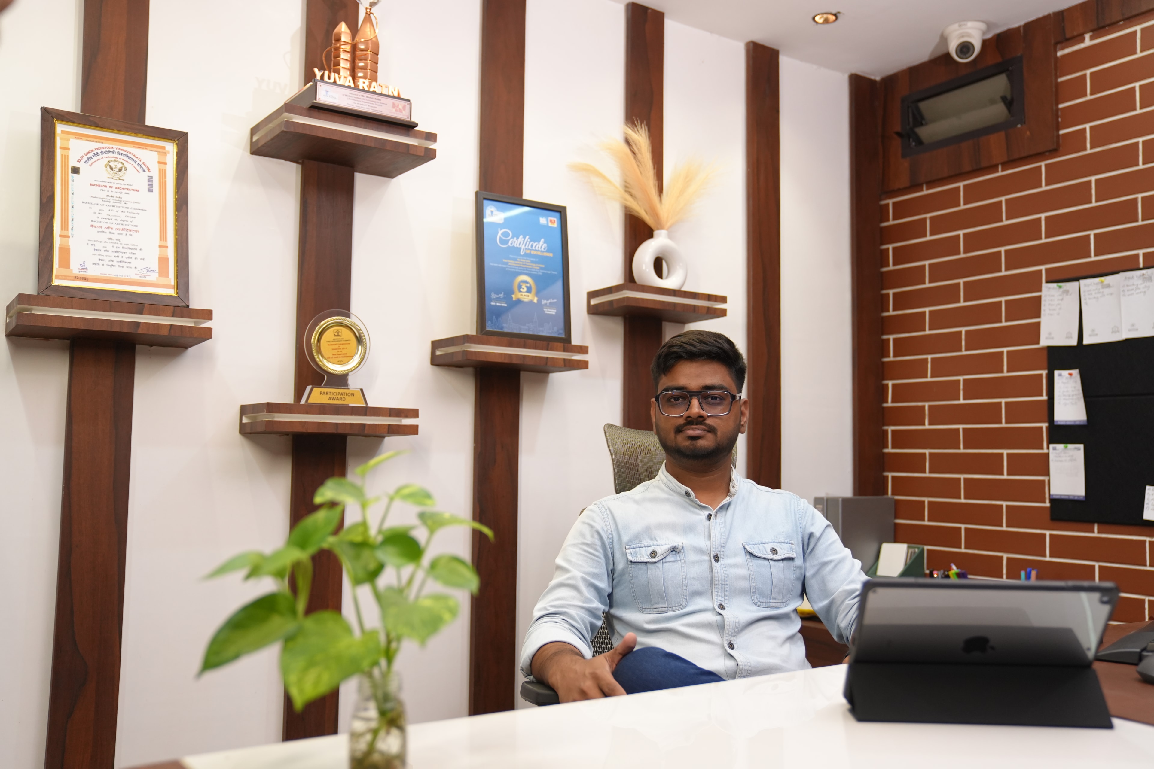 Ar. Mohit Sahu, Founder and Principal Architect of MRS Architects, at his studio desk beneath the studio's awards.