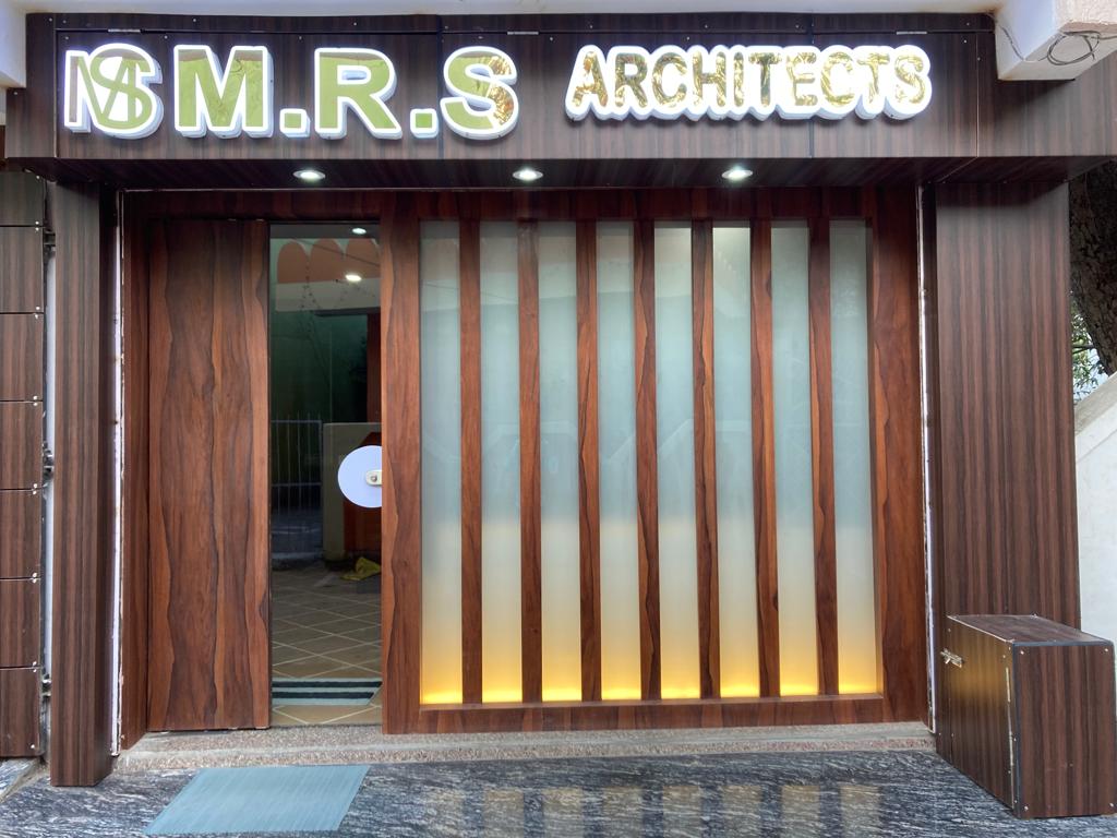 MRS Architects studio storefront — illuminated ‘M.R.S Architects’ signage on a rosewood facade with backlit frosted glass, Makronia, Sagar.